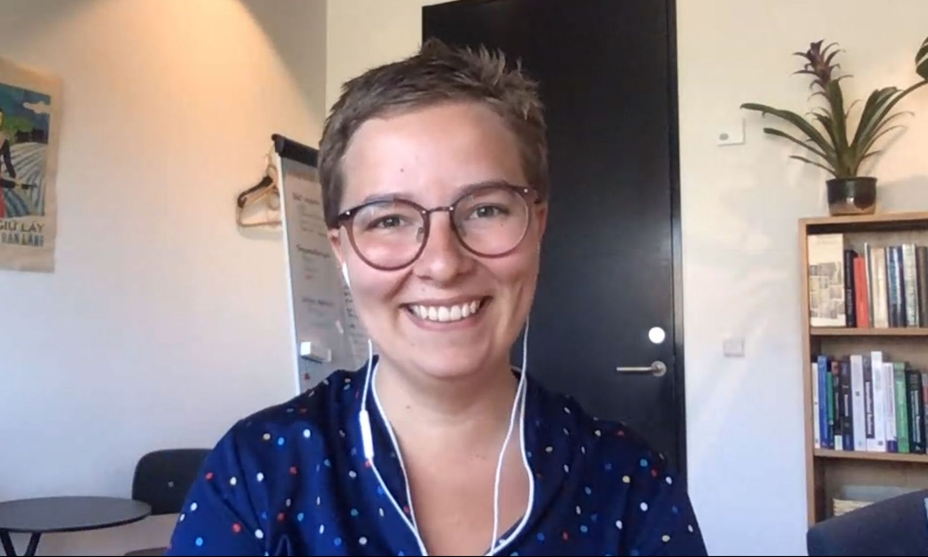 Woman with glasses, smiles in her office