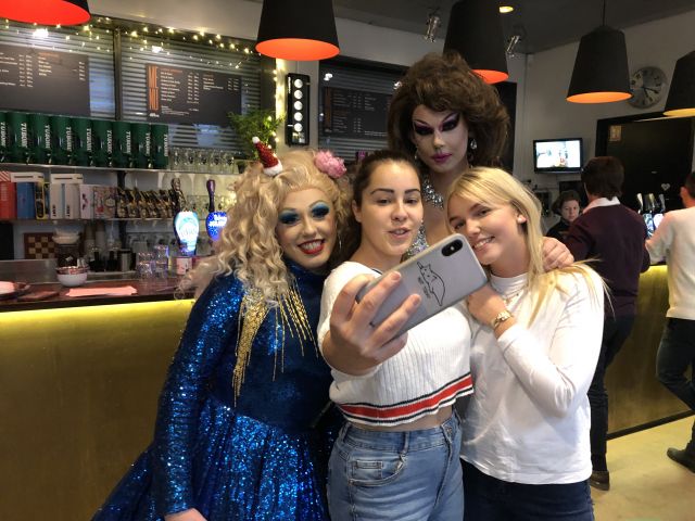 Drag queen taking pictures with friends