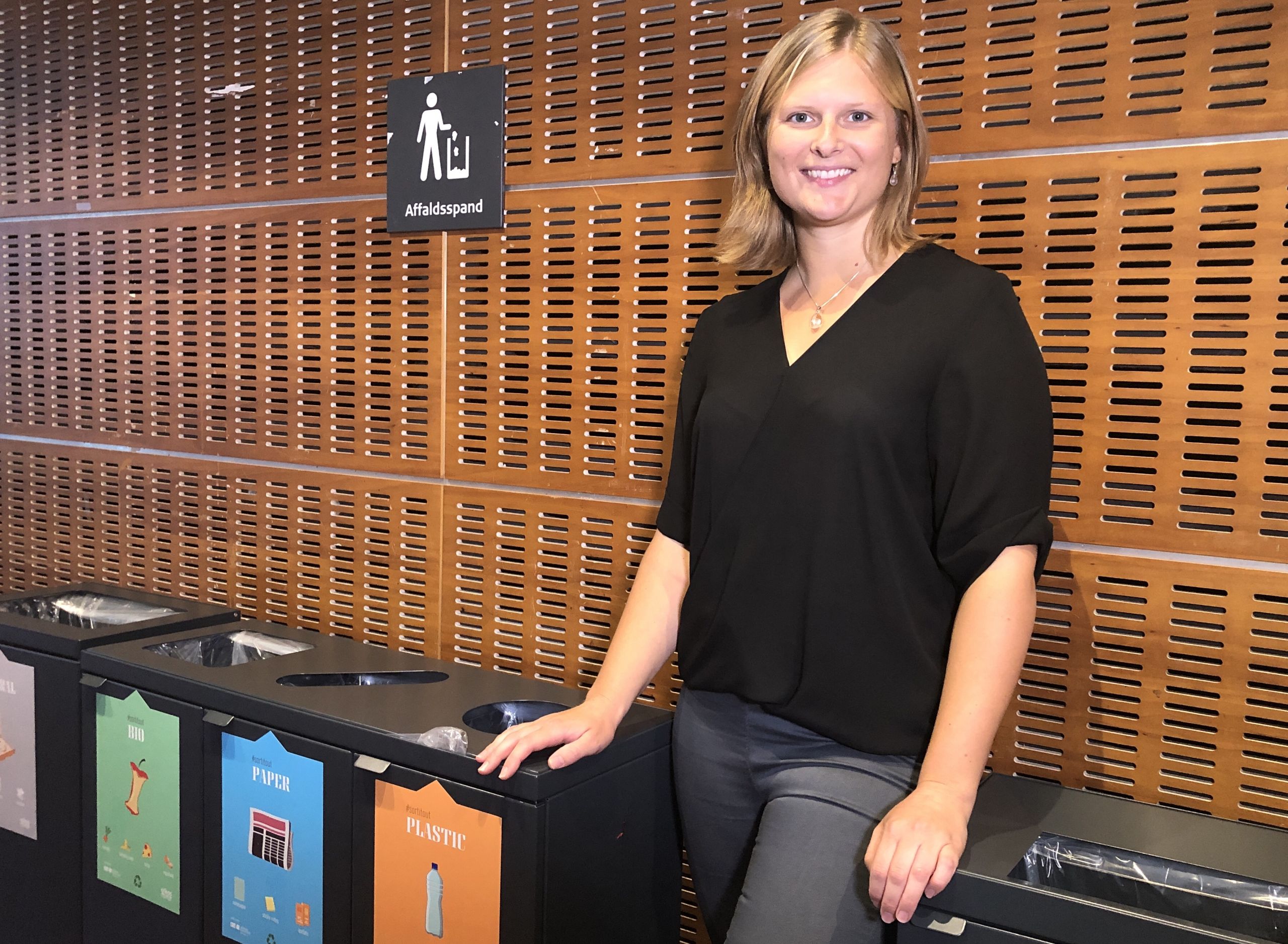 girl standing by trash cans