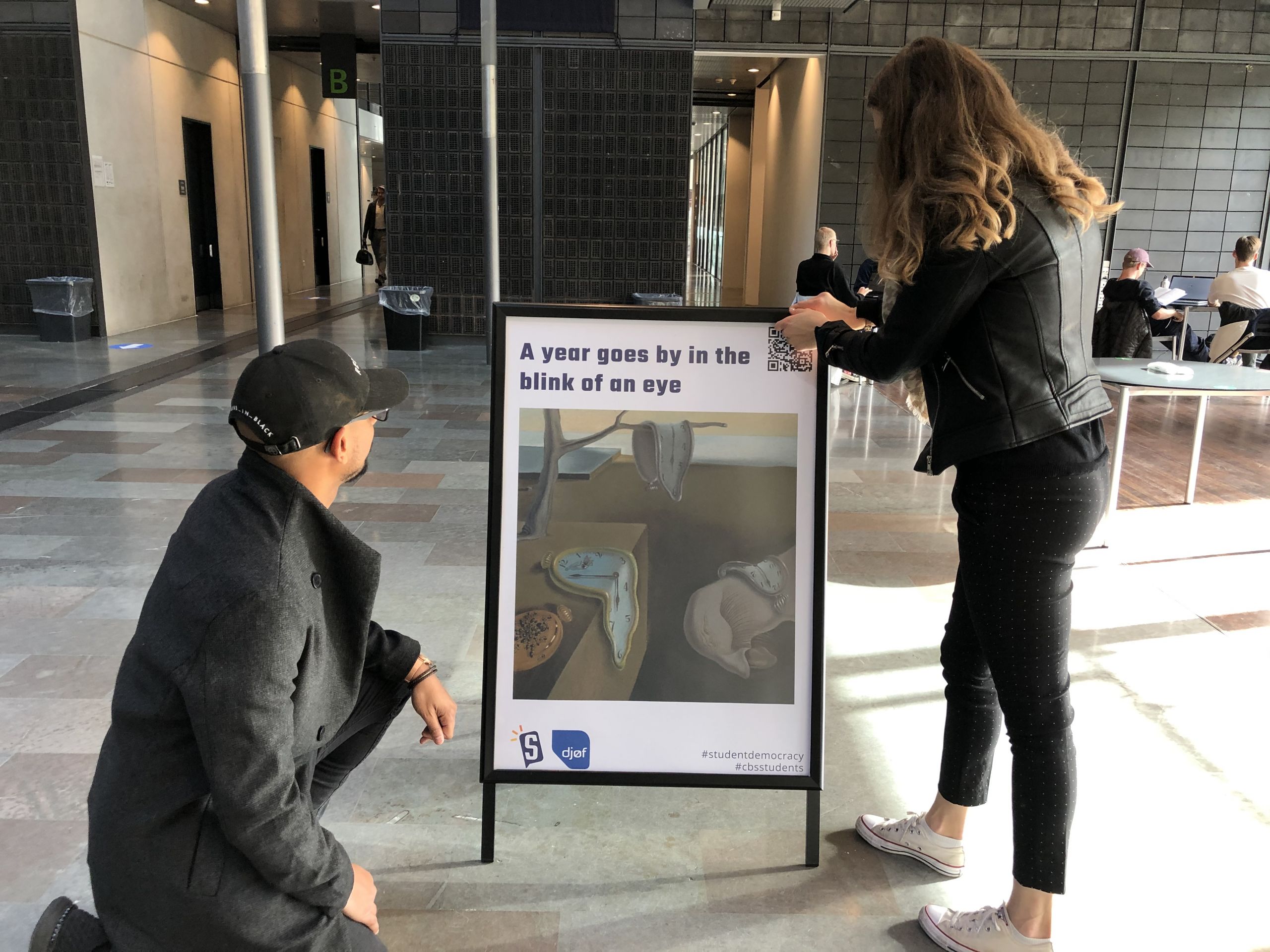 two students and a poster at CBS