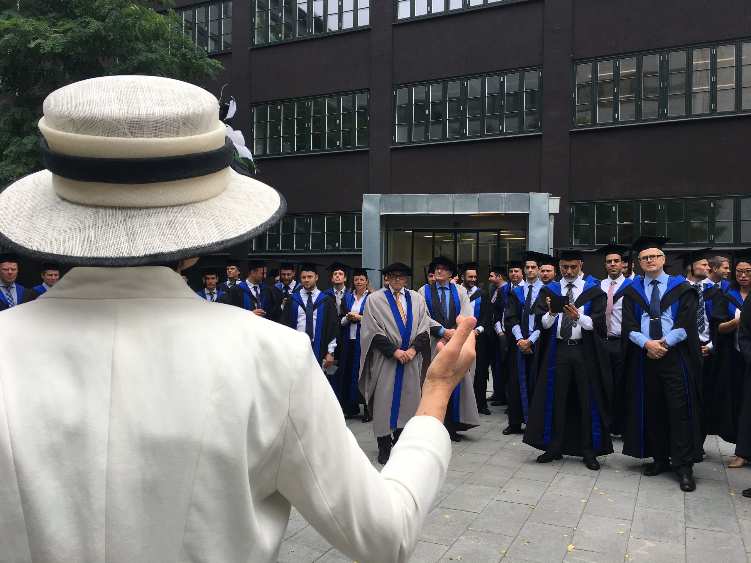 Woman in white speaking to graduates