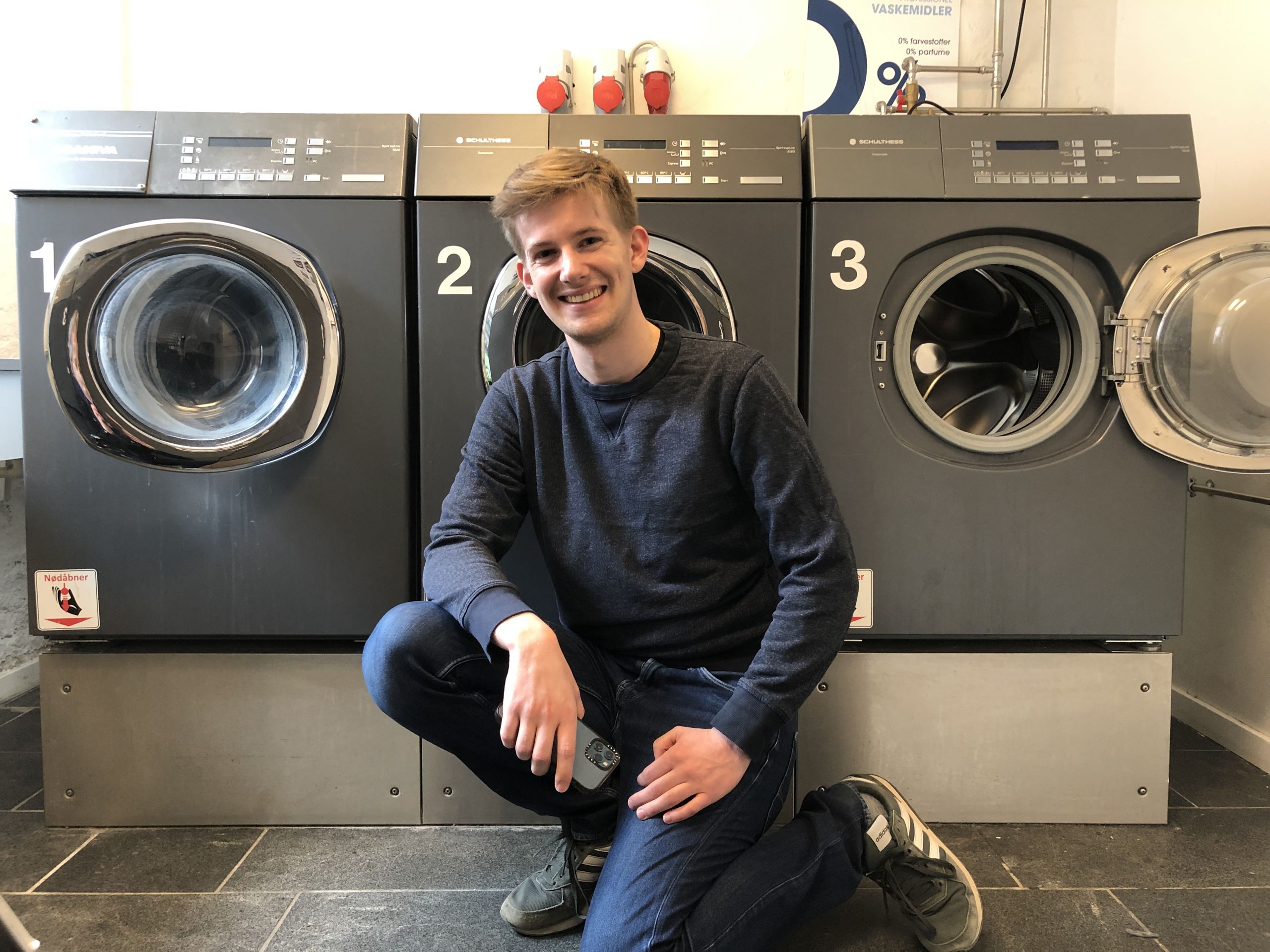 Man sitting in front of washing machines