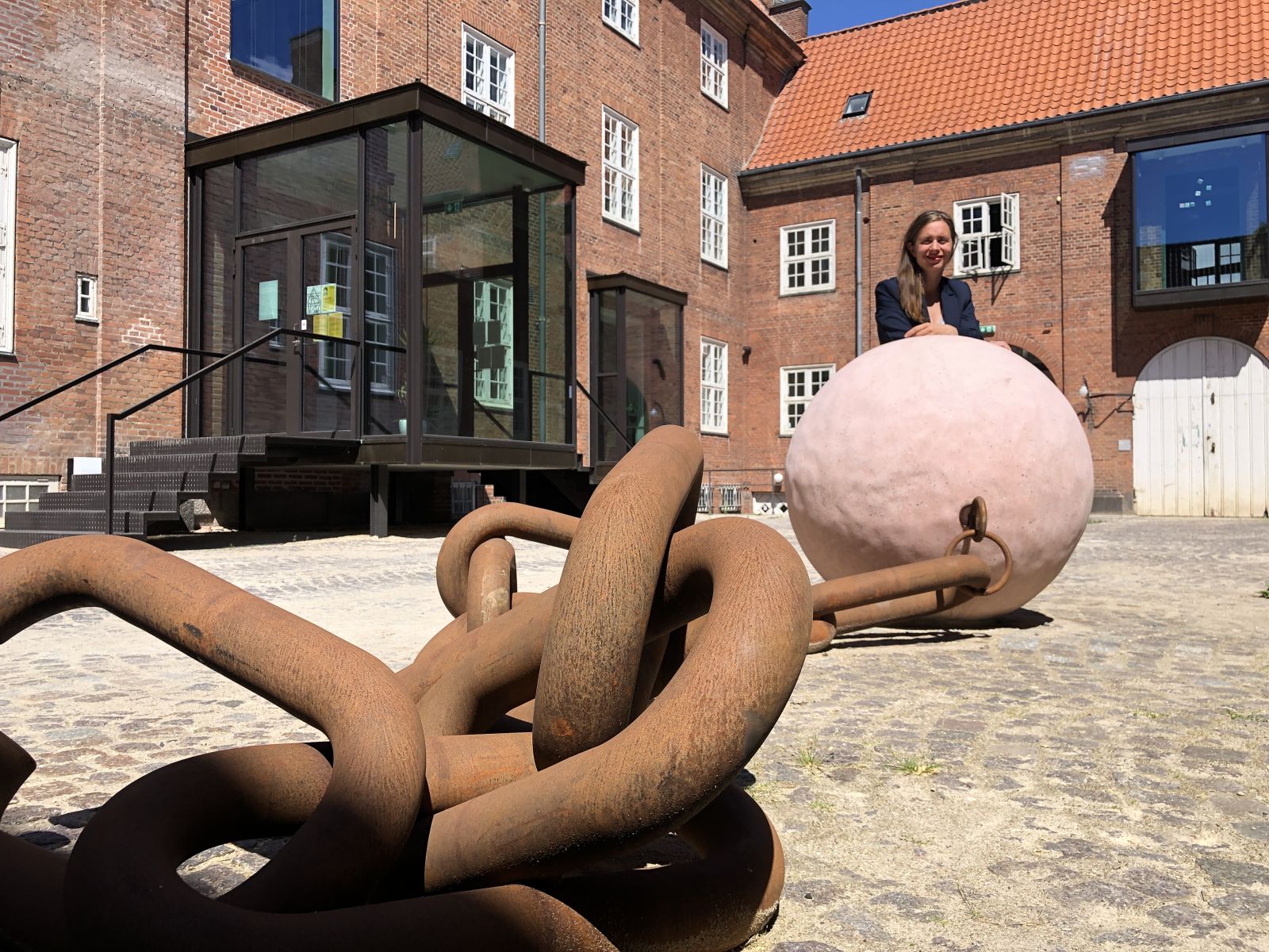 Woman by sculpture in front of Station