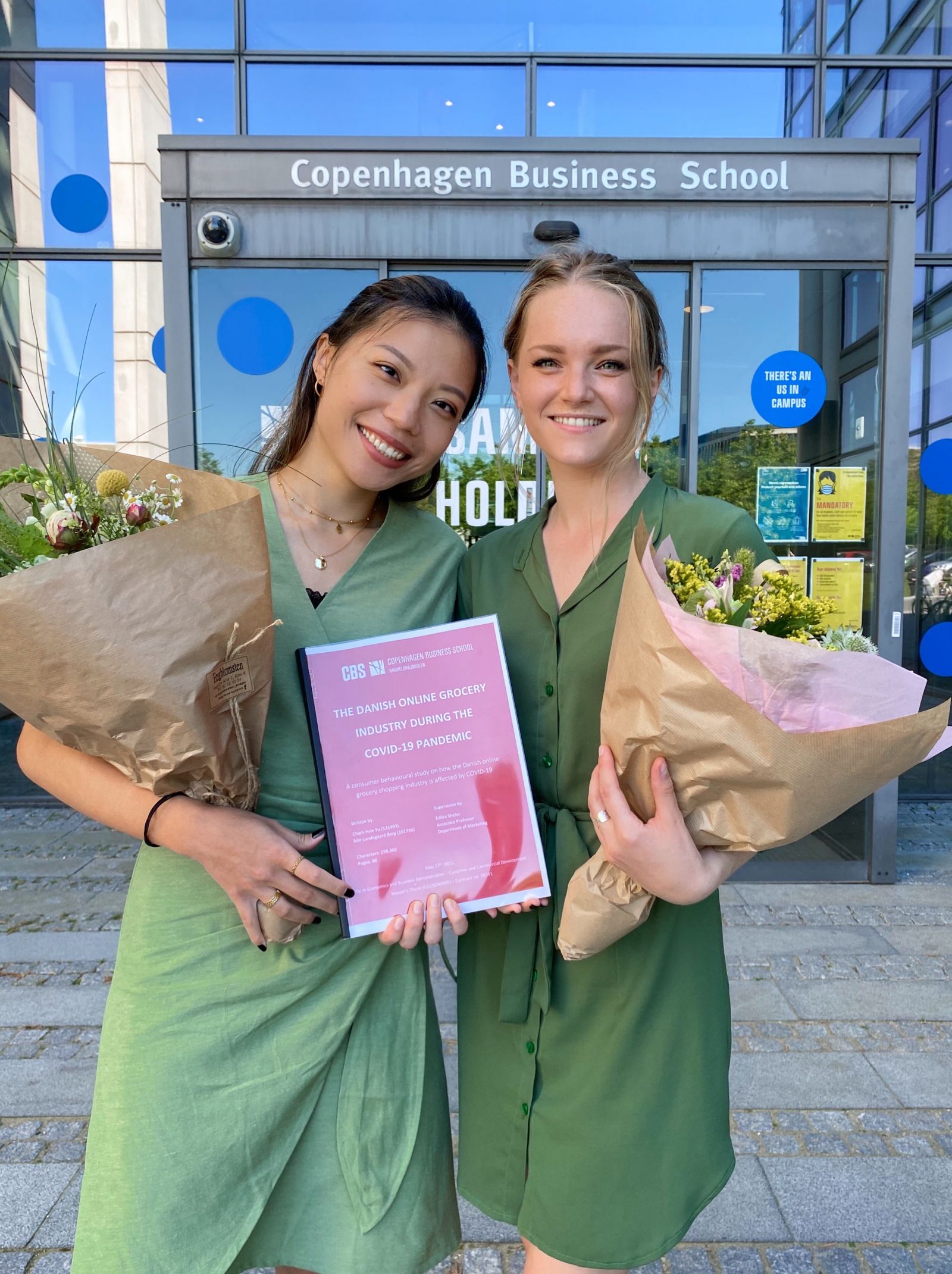 Two graduates with flowers