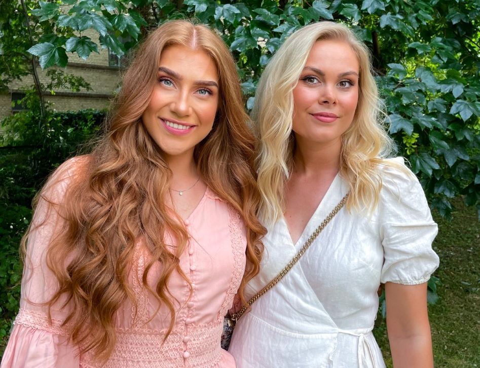 Two women in pink and white dresses