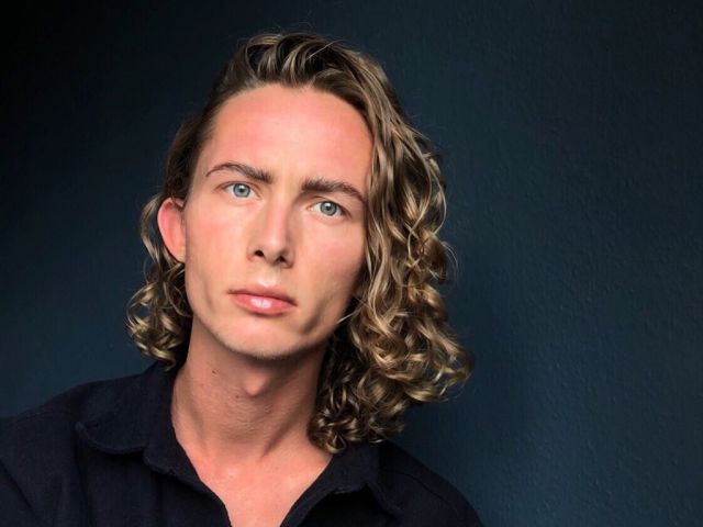 Man in black shirt with curly hair