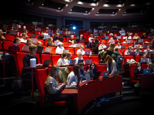 student in an auditorium at CBS